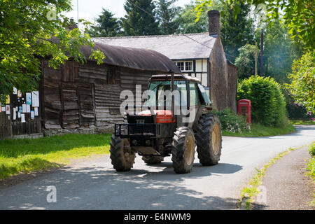 Ein Traktor fahren durch das Dorf Hopesay in Shropshire, England Stockfoto