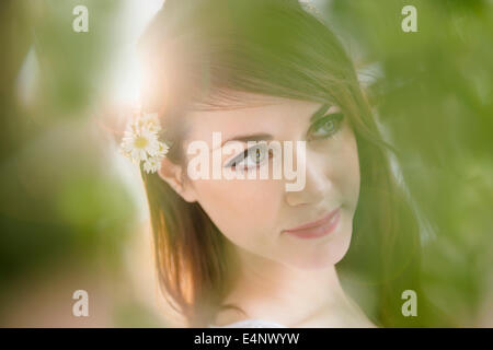 Porträt der jungen Frau mit Gänseblümchen im Haar Stockfoto