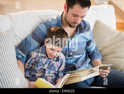 Vater mit seinem Sohn (8-9) Bücher zu lesen Stockfoto