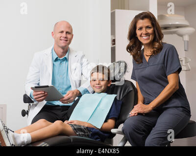 Porträt von Zahnarzt, Patient (12-13) und Assistent Stockfoto