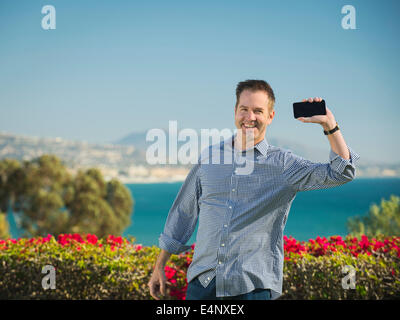 USA, California, Dana Point, Porträt von lächelnden Mann Holding smartphone Stockfoto