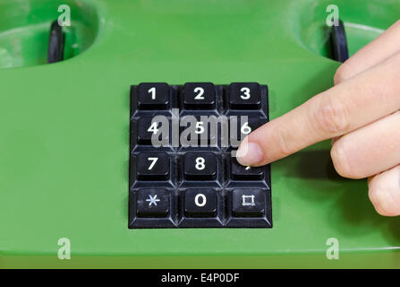 Menschliche Finger Tasten mit Zahlen auf alten Retro-Telefon. Dialing mit Telefon zu Hause. Stockfoto