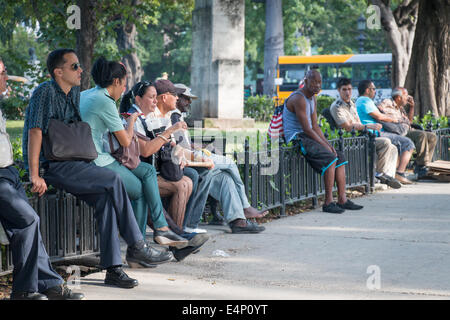 Leute sitzen im Parque De La Fraternidad, Capitolio, Havanna, Kuba Stockfoto