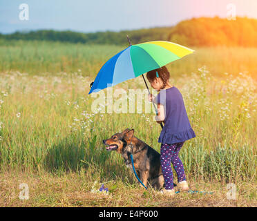 Kleines Mädchen mit Hund unter Dach bei sonnigem Wetter Stockfoto