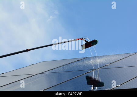 Sonnenkollektoren auf einem Wohneigentum werden gereinigt, mit einer hohen Reichweite und Waschwasser eingezogenen Pfosten Stockfoto