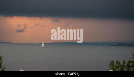 Matrosen fliehen einen Sturm zieht auf. Zwei kleine Segelboote laufen vor einem herannahenden Sturm bei Sonnenuntergang auf dem Ottawa River. Stockfoto