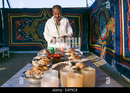 Kairo, Ägypten. 15. Juli 2014. Ein Mann bereitet Mahlzeiten für ein Charity-Bankett in Kairo, Ägypten, 15. Juli 2014. Nächstenliebe Bankette oder ma'idat al-Rahman, eine langjährige Tradition der Ramadan in Ägypten, vertreten durch die wohlhabende Gönner ihre weniger wohlhabenden Glaubensgenossen zu den Mahlzeiten bieten, das Fasten zu brechen. © Cui Xinyu/Xinhua/Alamy Live-Nachrichten Stockfoto