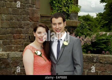 Junges Paar auf einer Hochzeit lächelnd in die Kamera Stockfoto