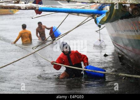 Provinz Cavite, Philippinen. 16. Juli 2014. Fischer halten Seile wie sie die starken Winde von Taifun Rammasun in der Provinz Cavite, Philippinen, 16. Juli 2014 mutig. Mindestens 5 Personen wurden getötet, nach dem Ansturm der Taifun Rammasun (lokaler Name: Glenda) die gelähmt der philippinischen Hauptstadt von Metro Manila am Mittwoch. Bildnachweis: Rouelle Umali/Xinhua/Alamy Live-Nachrichten Stockfoto