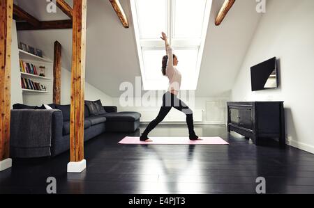 In voller Länge Portrait von gesunden jungen Dame gehen Yoga Training zu Hause. Fitness-Modell im Wohnzimmer ausüben. Stockfoto