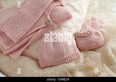 Gestrickte rosa Neugeborene Kleidung, Jacke, Hut und booties Stockfoto