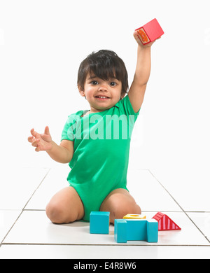 Junge (16 Monate) spielen mit bunten Blöcken Stockfoto