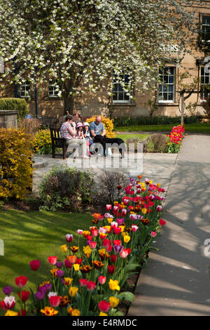 UK, Derbyshire, Peak District, Bakewell, öffentlichen Park Bad Gärten, Besucher auf Bank unter den bunten Blumen Stockfoto