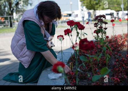 Moskau, Russland. 16. Juli 2014. Eine Frau zündet eine Kerze in der Nähe von Park Pobedy Bahnhof am 16. Juli 2014, in Moskau, Russland. Einwohner in Moskau legte Blumen und Kerzen beleuchtet, in der Metro-Station, ihr Beileid für die Opfer des Moskaus tödliche u-Bahn Entgleisung zu vermitteln. Nach den jüngsten Statistiken, mindestens 22 Menschen starben und Hunderte Verletzte mehr in einer u-Bahn Zugentgleisung am Dienstag, der schwerste Unfall in der Moskauer u-Bahn-Geschichte stammt aus dem Jahr 1935 geworden ist. Bildnachweis: Dai Tianfang/Xinhua/Alamy Live-Nachrichten Stockfoto