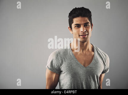 Porträt von hübscher Junge hispanic männliche Mode Model posiert vor grauem Hintergrund mit Textfreiraum. Stockfoto