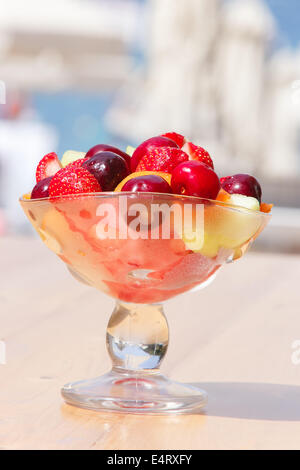 Salat von Früchten. Gesundes Obstsalat in der Glasschüssel auf schönen Sonnenstrand Stockfoto