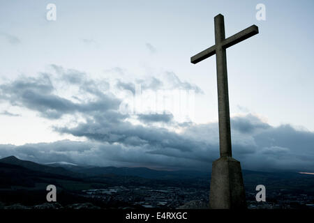 Christliches Kreuz Silhouette auf dem Gipfel des Berges. Bray, Irland. Stockfoto