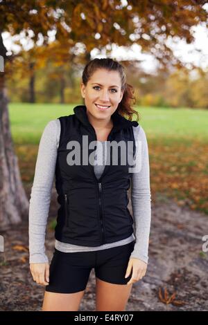 Porträt der jungen Sportlerin in Sportbekleidung, Blick auf die Kamera zu Lächeln. Schöne kaukasischen Frau Fitness Modell stehen Stockfoto