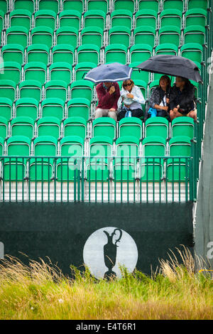 Zuschauer sitzen unter Sonnenschirmen auf einem der British Open Golf am Golfplatz Royal Liverpool für die British Open 2014 wie es regnet Stockfoto
