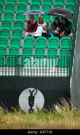 Zuschauer sitzen unter Sonnenschirmen auf einem der British Open Golf am Golfplatz Royal Liverpool für die British Open 2014 wie es regnet Stockfoto