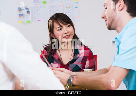 Nahaufnahme von drei jungen Geschäftsleuten treffen und diskutieren in Office, Deutschland Stockfoto