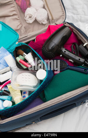 Frauen Travel Kulturbeutel in gepackten Koffer Stockfoto