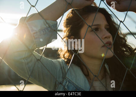 Close-up Portrait von Teenager-Mädchen stehen im Freien neben Maschendrahtzaun, Deutschland Stockfoto