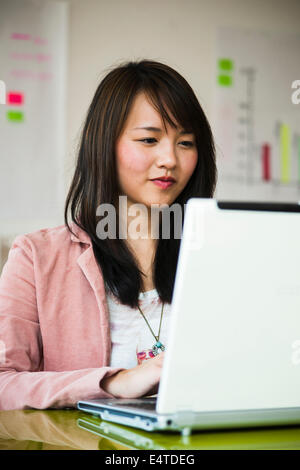 Junge Frau, die arbeitet auf Laptop-Computer im Büro, Deutschland Stockfoto