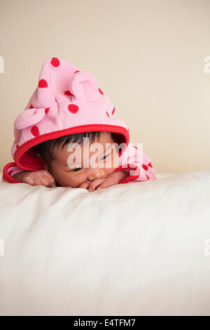 Porträt von zwei Wochen alten, Neugeborenen asiatisches Babymädchen in rosa gepunkteten Kapuzenjacke, Studio gedreht auf weißem Hintergrund Stockfoto