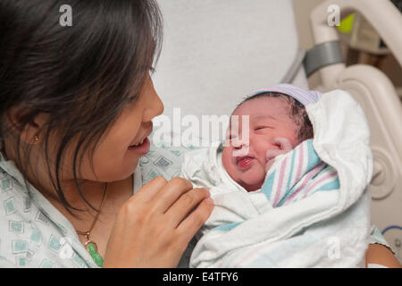 Stolze Mutter hält Neugeborene Baby-Mädchen zum erstenmal Stockfoto
