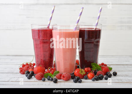 Drei Gläser von Smoothies mit verschiedenen Beeren auf hölzernen Hintergrund Stockfoto