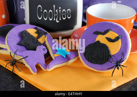 Happy Halloween-party Süßes oder Saures lila und orange Cookies mit Spinnen und Keksdose - hautnah. Stockfoto