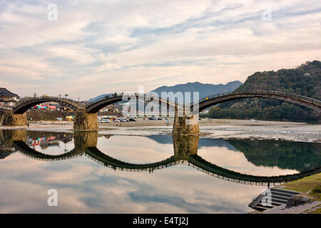 Die historische Holzbogenbrücke Kintai, die den Nishiki River bei Iwakuni am späten Nachmittag überspannt, mit ihrer Spiegelung im Fluss. Stockfoto