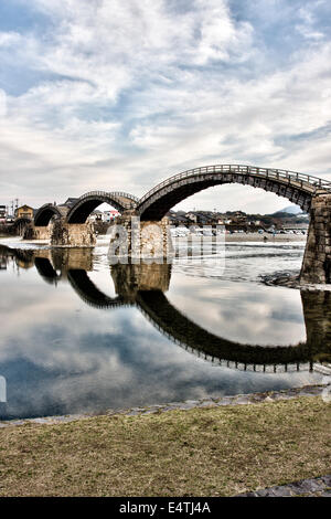 Die historische Holzbogenbrücke Kintai, die den Nishiki River bei Iwakuni am späten Nachmittag überspannt, mit ihrer Spiegelung im Fluss. Stockfoto