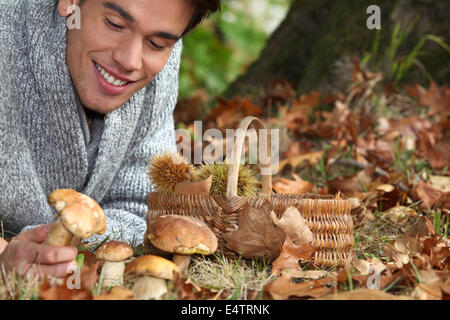 Mann auf dem Boden sammeln von Pilzen Stockfoto