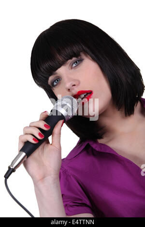 Frau in ein Mikrofon singen Stockfoto