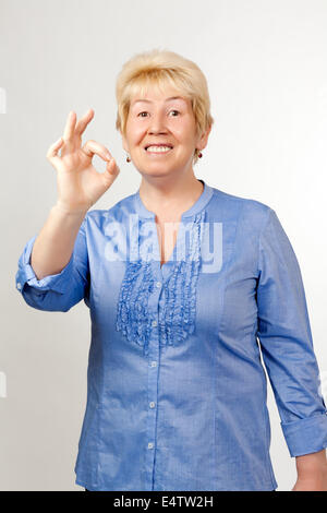 Frau mittleren Alters zeigt "OK" Stockfoto