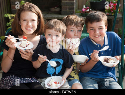 Kinder essen Eis und Kuchen bei einer Familienfeier Stockfoto