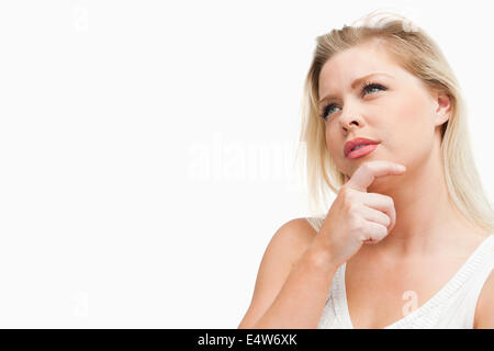 Attraktive blonde Frau, die in Gedanken verloren Stockfoto