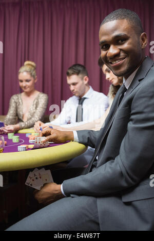 Mann zeigt Pokerhand unter Tisch Stockfoto