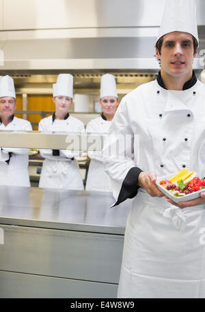 Küchenchef präsentiert Obstsalat Stockfoto