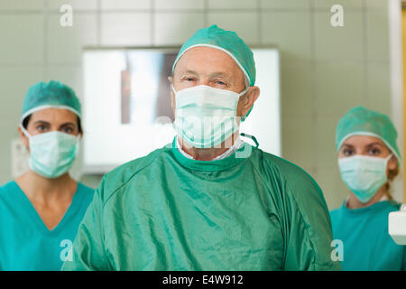 Chirurg mit zwei Praktikanten hinter ihm Stockfoto