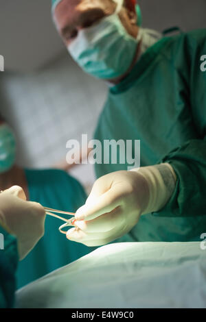 Chirurg unter Schere aus einer behandschuhten hand Stockfoto