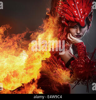 Mädchen am Feuer, Steampunk, schöne Frau, gekleidet in roten Rüstung Drachenschuppen Stockfoto