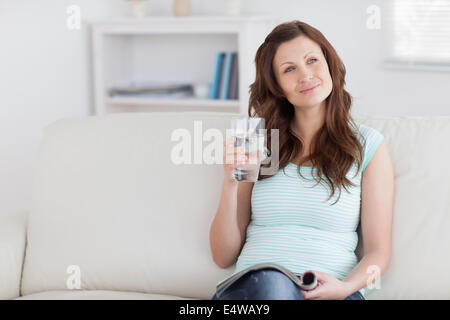 Nachdenkliche Frau mit einem Glas Stockfoto