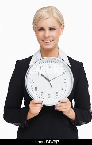 Schweren Blondine im Anzug hält eine Uhr Stockfoto