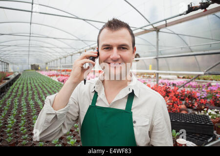 Mitarbeiter am Telefon im Gewächshaus Stockfoto