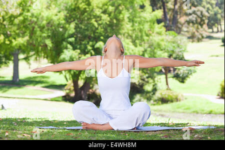 Frau auf dem Rasen, die Yoga-Übungen Stockfoto