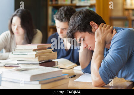 Schüler beim Einschlafen in Bibliothek Stockfoto