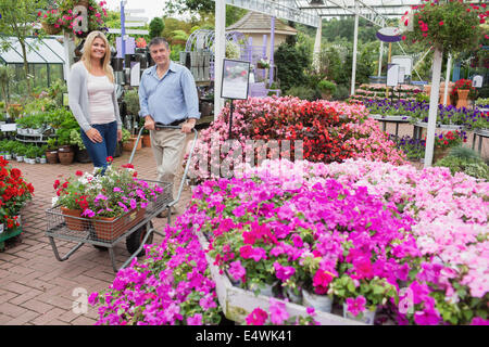 Paar schieben Wagen voller Blumen Stockfoto